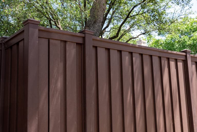 Close detail of brown Trex composite privacy fence panels and posts