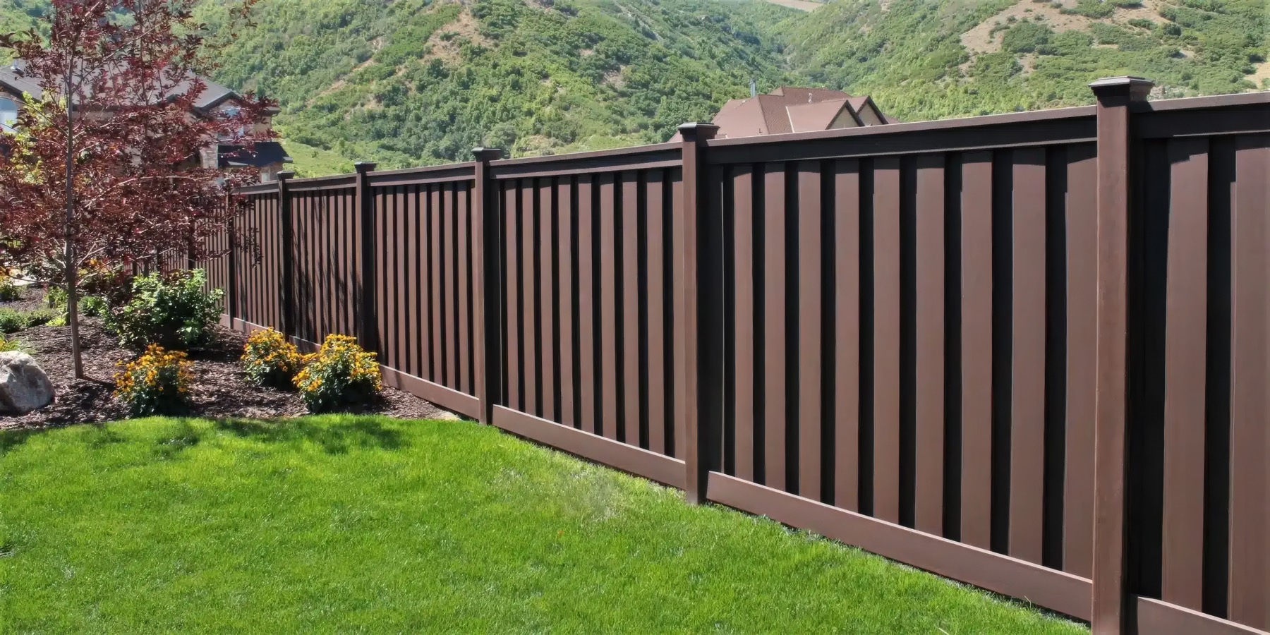 Trex composite fence running through a landscaped hillside yard